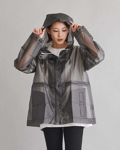 透明でグレー色のフルトンクリアコートを着たフードを被った女性